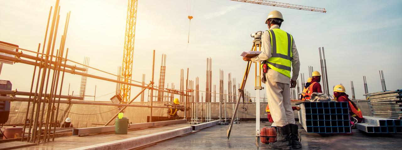 Construction workers surveying a building site at sunrise
